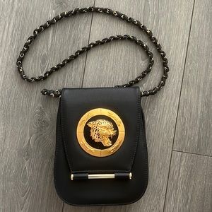 Black and gold crossbody purse with metal cat image on front